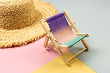 Colorful beach chair, straw hat on colorful background. Summer, holidays and beach concept....