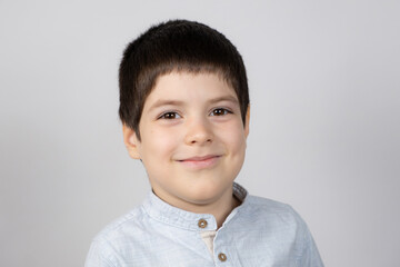 Portrait of a six-year-old European boy on a light gray background.
