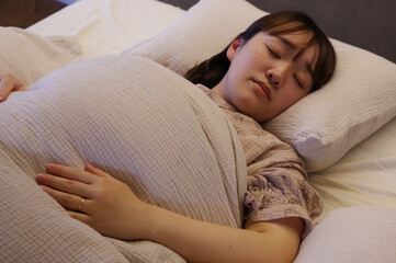 ベッドで就寝する若い女性