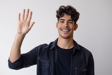Smiling Young Man in Black Shirt Waving Hand and Greeting Camera Against White Background