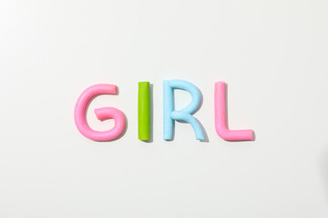 The word "girl" is made of colored plasticine on a white background.
