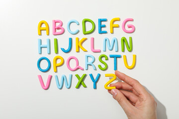 Alphabet made of colored plasticine on a light background.
