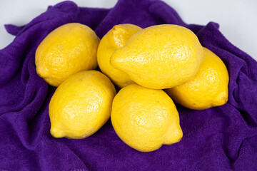 Lots of fresh whole lemons on a vioette background close-up
