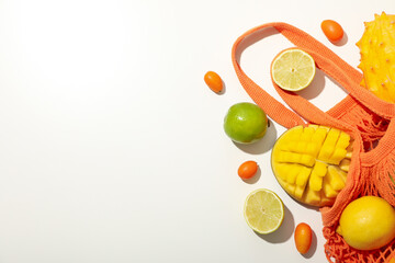 Set of tropical fruit in bag on white background, space for text