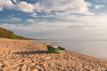 Baltic sea sandy beach with fishing boat on the shore in Saulkrasti, Latvia