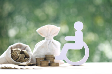 Man on wheelchair and coin money on natural green background,Save money for prepare in future and...