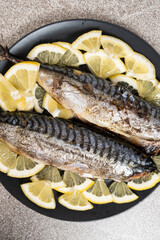 Oven-baked mackerel sea fish dish served with fresh lemon slices