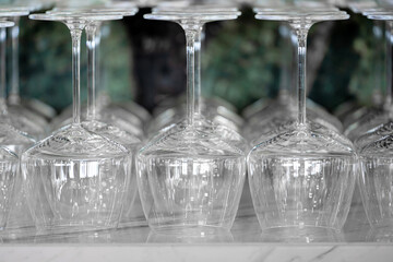 Wine glasses arranged upside down on the marble counter at the bar