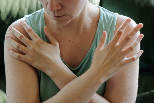 Woman tapping her shoulders, crossing hands. Butterfly hug self-care technique.