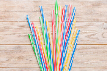many multi-colored plastic tubes for cocktail on Colored background, top view