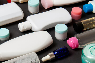 Top view of different cosmetic bottles and container for cosmetics on colored background. Flat lay...