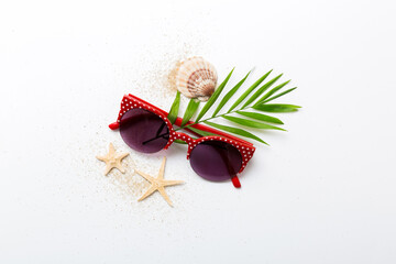 sunglasses with seashell lying on table background. Sunglasses on summer background. Top view flat...