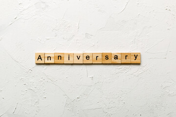 anniversary word written on wood block. anniversary text on cement table for your desing, concept