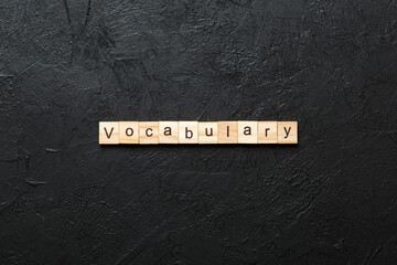 vocabulary word written on wood block. vocabulary text on table, concept