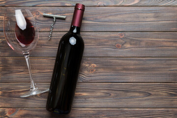 Flat lay composition with corkscrew, bottle of wine and elegant glass on colored table. Flat lay,...