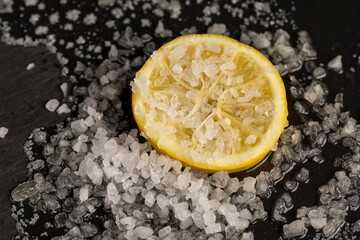 ripe yellow lemon and salt on a black board