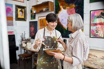 Two older women create art in a cozy studio.