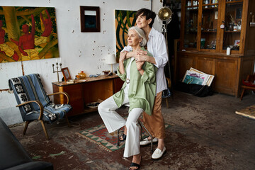 A mature lesbian couple in an art studio, standing together.