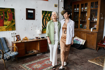 Mature lesbian couple standing together in an art studio.