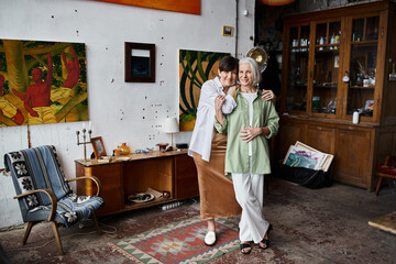 Two women standing together in an art studio.