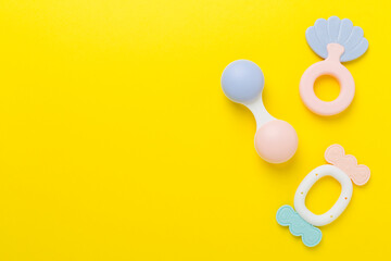 Colorful baby rattles and toys on color background, top view