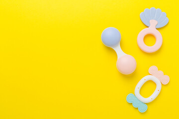 Fototapeta premium Colorful baby rattles and toys on color background, top view