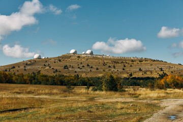 Astronomy Observation Site with Two Large Telescopes on Top of Hill in Scenic Field Environment