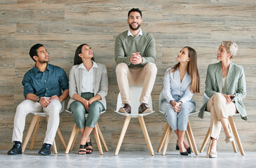 Waiting room, business people or employees sitting in row with man higher for confidence or...