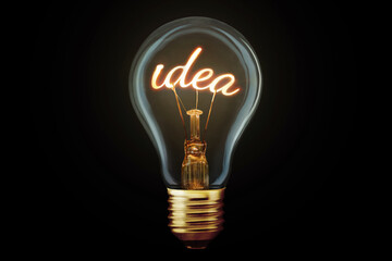 Creative light bulb with filament Idea glows on black background, concept. Think differently,...