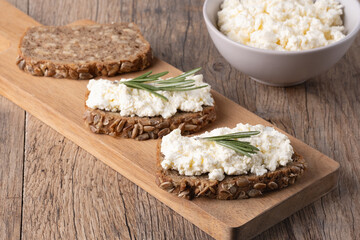 Home made rye bread on a wooden cutting board with curd cheese