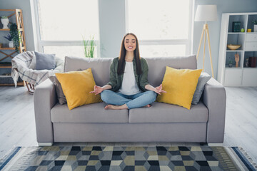 Full length portrait of nice young girl meditate wear green shirt modern interior flat indoors