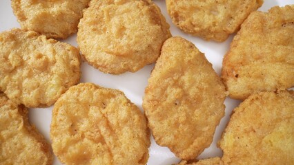 A chicken nugget is a small, breaded and deep-fried piece of chicken meat, often made from ground or minced chicken, and served as a fast-food snack or meal component. Food background. 
