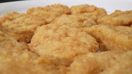 Chicken nuggets traditionally made with breast meat, but variations include ground chicken, turkey, or plant-based ingredients for vegetarians and vegans. Junk food concept. Food background.
