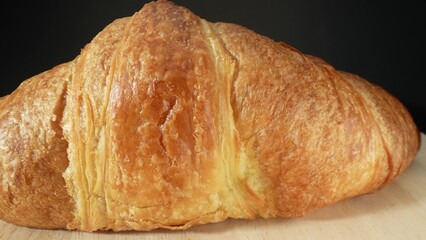 Croissant dough shaped into crescents, proofed, then baked to golden perfection. Crispy, golden exterior; soft, tender layers inside. Junk food concept. Shot with 24mm probe macro lens. Food concept.
