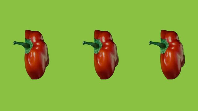 Juicy ripe red sweet pepper halves rotate on a bright green background with alpha channel. The pattern of fresh vegetables is perfect for food and kitchen themes.