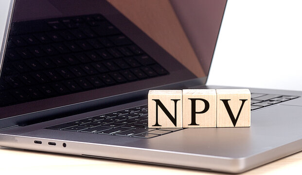 NPV word on wooden block on a laptop , business concept