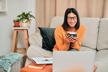Smile, coffee and woman with laptop on sofa for online subscription, streaming movie or series in living room. Weekend, drinking tea and person with cup for comedy film, video or entertainment home