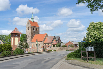 Obraz premium Village street in Groß Schwechten with Romanesque village church made of field stones, Saxony-Anhalt, Germany