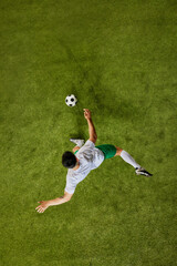 Top-down perspective of footballer executing powerful kick, showcasing their athletic prowess on...