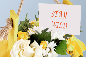 Financial concept meaning STAY WILD words written on a card inserted into a bouquet of flowers