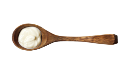 A wooden spoon is filled with cream against a white background