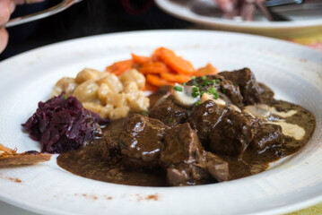 Closeup of beef meat with sauce and vegetables in a plate at the restaurant