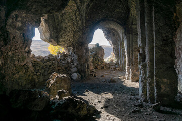 Inside in an antique rock-hewn church. Columns with arches and bas-reliefs. Samsari, Georgia