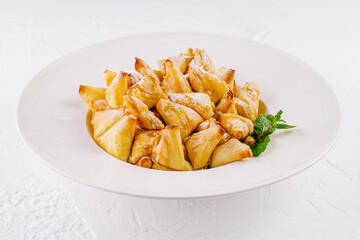 Golden caramelized apple pancakes dessert on white plate