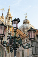 Obraz premium Historic clocktower and ornate street lamps overlooking a town square in Italy.