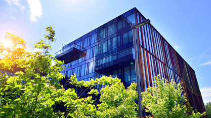 Sustainable glass office building with trees for reducing carbon dioxide. Eco-friendly building in modern city. Office with green environment. Corporate building reduce CO2.