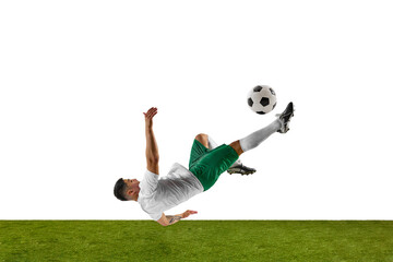 Soccer player in mid-air performs bicycle kick, with ball above on lush green grassland against...