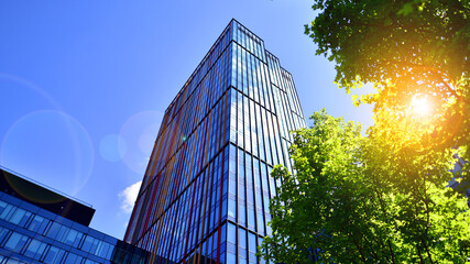 Sustainable glass office building with trees for reducing carbon dioxide. Eco-friendly building in...