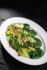 Fresh green vegetable salad with pomegranate seeds
