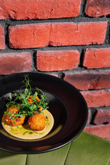 Gourmet fried balls on elegant black plate